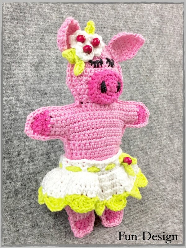 Gehäkeltes rosa Schweinchen-Amigurumi mit weiß-gelbem Rock, Blüte und Perlen