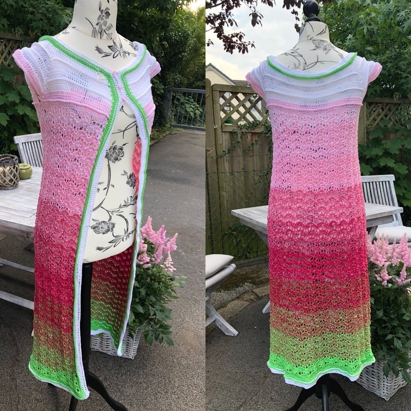 Lange gehäkelte Damenweste mit Farbverlauf in Weiß, Pink und Grün auf einer Schneiderbüste