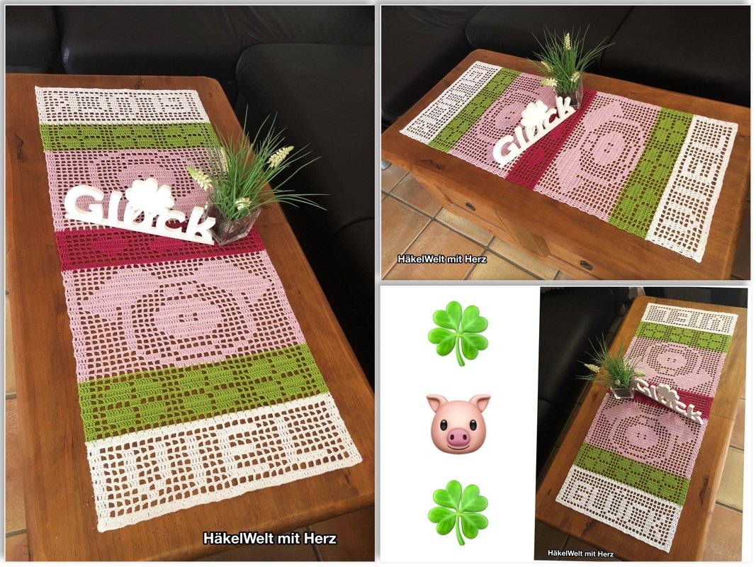 Rechteckiger Filet‑Häkel‑Tischläufer mit Schwein‑ und Kleeblattmotiven; Streifen in Weiß, Grün, Rosa und Bordeaux; dekoriert auf einer Holzkommode mit Pflanze und Schriftzug ‚Glück‘