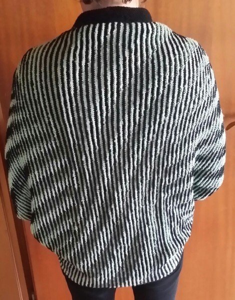 Rückenansicht eines gestrickten Seelenwärmers mit schwarz-weißen vertikalen Streifen