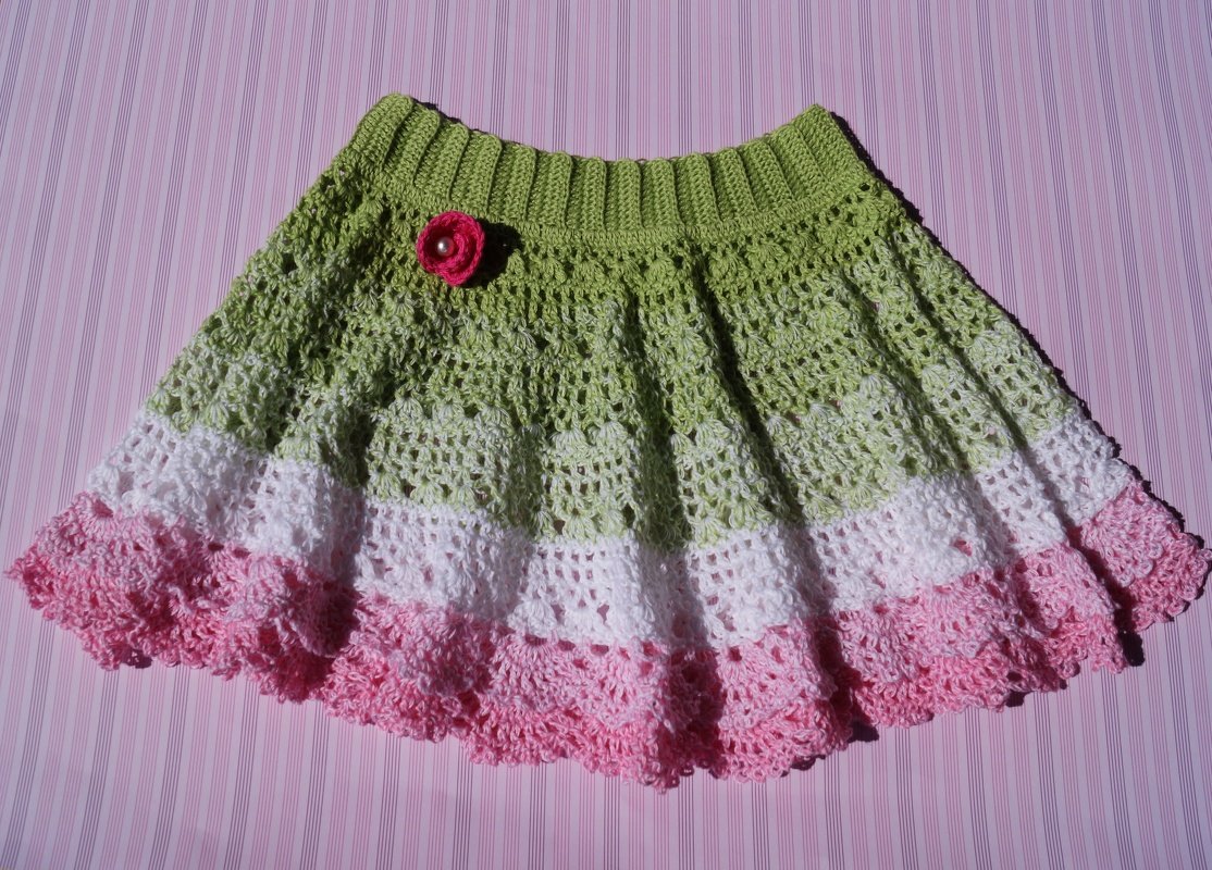 Gehäkelter Kinderrock in Grün, Weiß und Rosa mit Rippenbund und Blumenapplikation