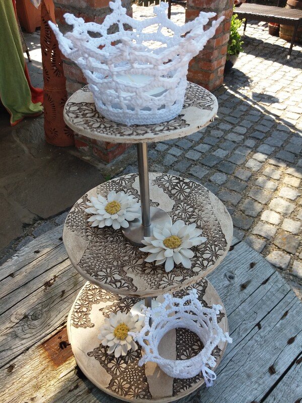 Dreistöckige Holz-Etagere mit zwei gehäkelten weißen Kronen und weißen Blumen