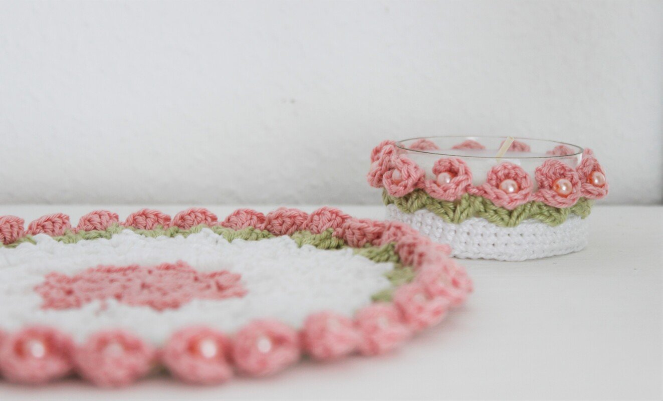 Weißes gehäkeltes Deckchen und passender Kerzenhalter mit rosa Blüten und Perlen