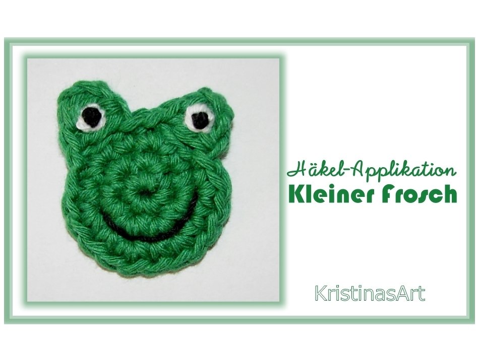 Grüne gehäkelte Frosch-Applikation mit weißen Augen und schwarzem Lächeln