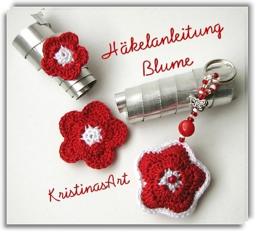 Drei gehäkelte rote und weiße Blumen: eine Applikation, eine auf einem Dekoelement und ein Schlüsselanhänger mit Perlen und Schmetterling.