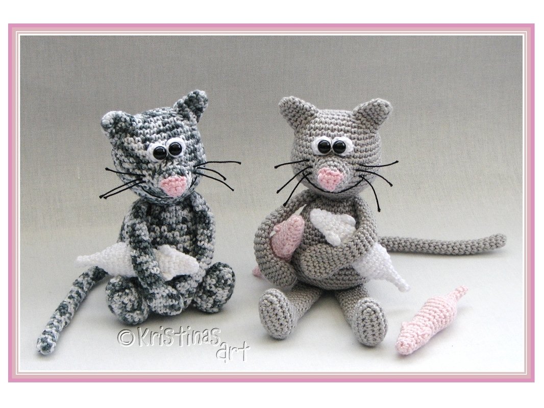 Zwei gehäkelte Amigurumi-Katzen (grau gesprenkelt und hellgrau) mit kleinen gehäkelten Mäusen