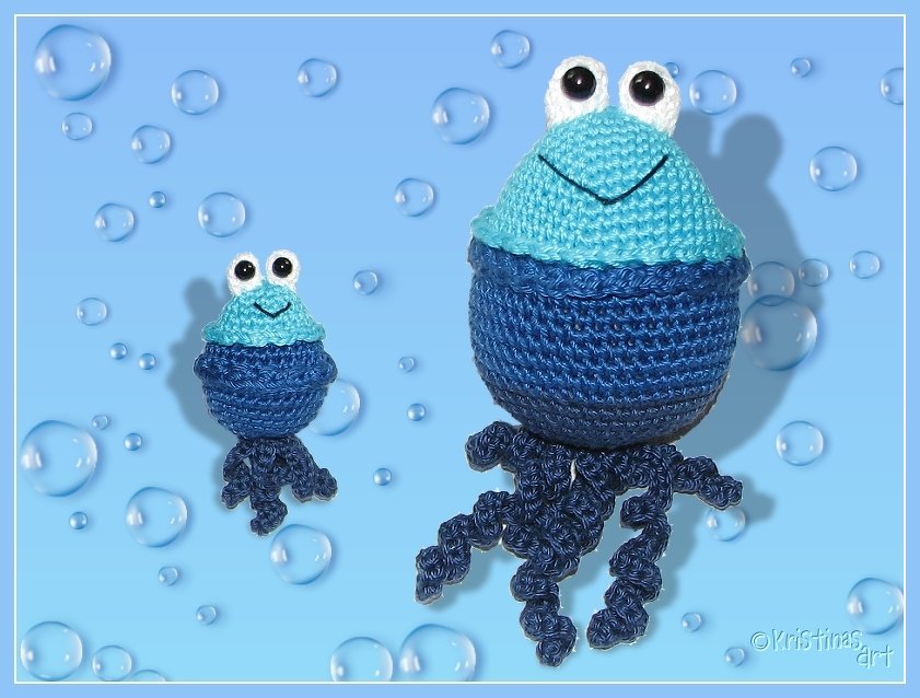 Zwei handgehäkelte Amigurumi-Quallen in Blau, groß und klein, mit Kulleraugen und gewellten Tentakeln