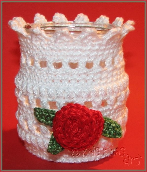 Weiße gehäkelte Windlicht-Hülle mit Lochmuster und roter Rose