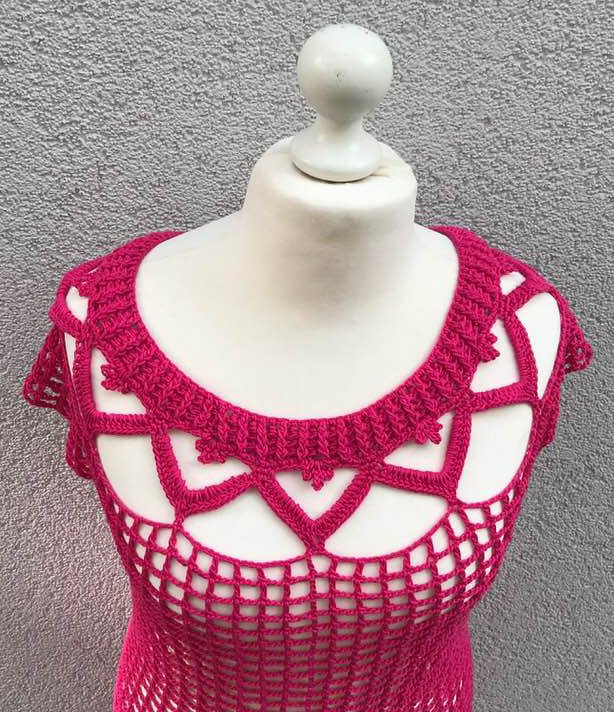 Fuchsiafarbenes Häkelshirt mit durchbrochenem Halsausschnitt und Gittermuster auf einer Schaufensterpuppe