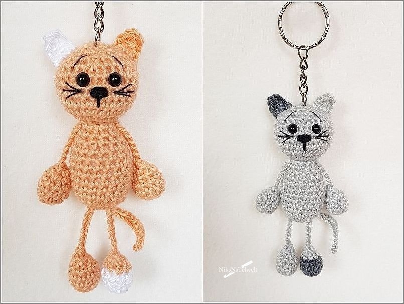 Zwei gehäkelte Katzen-Amigurumi Schlüsselanhänger in Orange und Grau