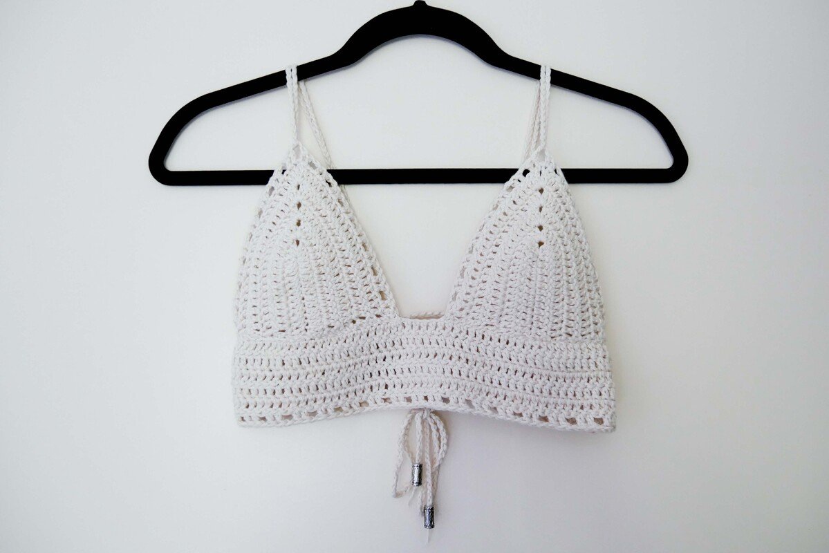Weißes gehäkeltes Top mit Triangelcups und Bindeband an schwarzem Bügel