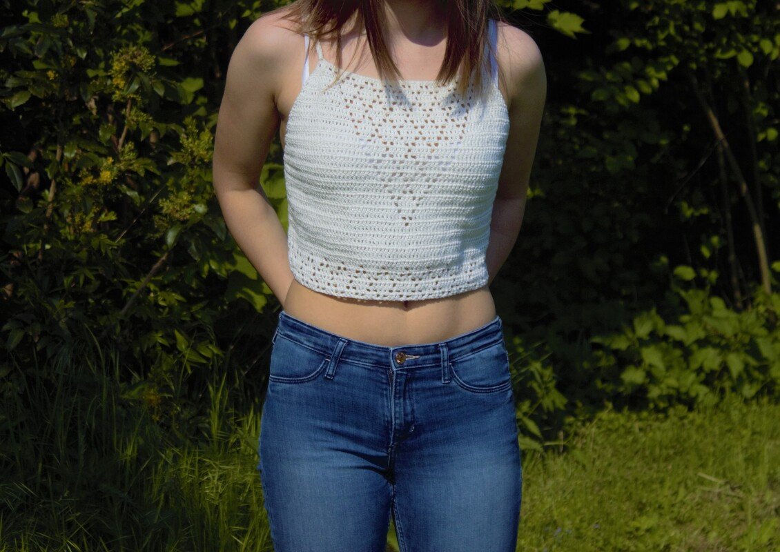 Weißes gehäkeltes Crop-Top mit Herzmuster, kombiniert mit blauen Jeans