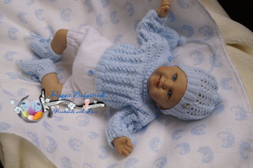 Gestricktes Baby-Outfit hellblau und weiß: Pullover, Hose, Mütze und Schühchen auf Babypuppe