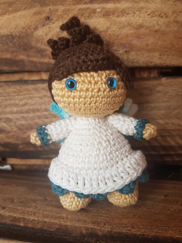 Handgehäkeltes Amigurumi-Engelchen mit blau-türkisen Akzenten und sichtbaren Details