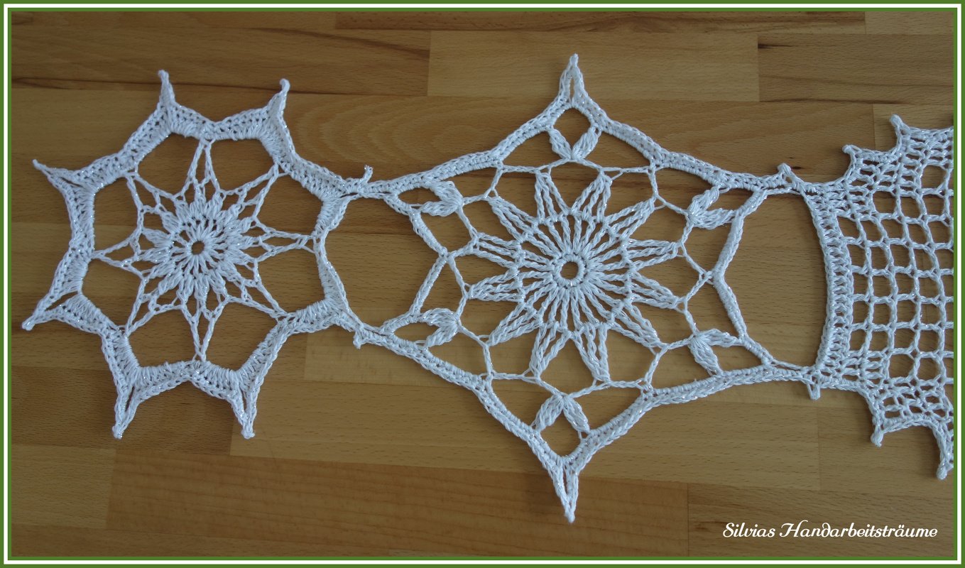 Detailansicht verbundener gehäkelter Motive mit Netzrand auf Holz