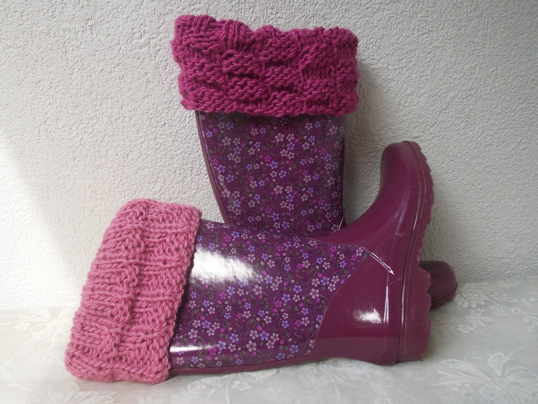 Lila Gummistiefel mit wei
f
-lilafarbenen Blumen und umgeschlagenen rosa gestrickten Stulpen