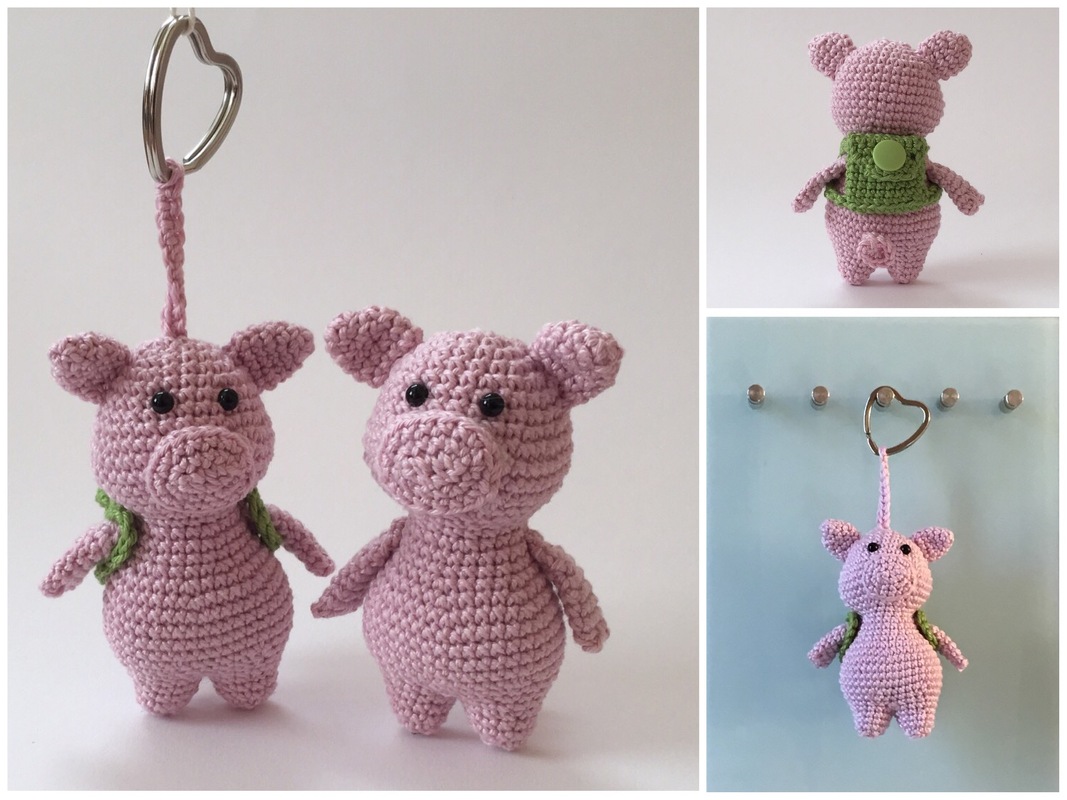 Zwei rosa gehäkelte Amigurumi‑Schweine: eines mit grünem Rucksack und herzförmigem Schlüsselring als Schlüsselanhänger.