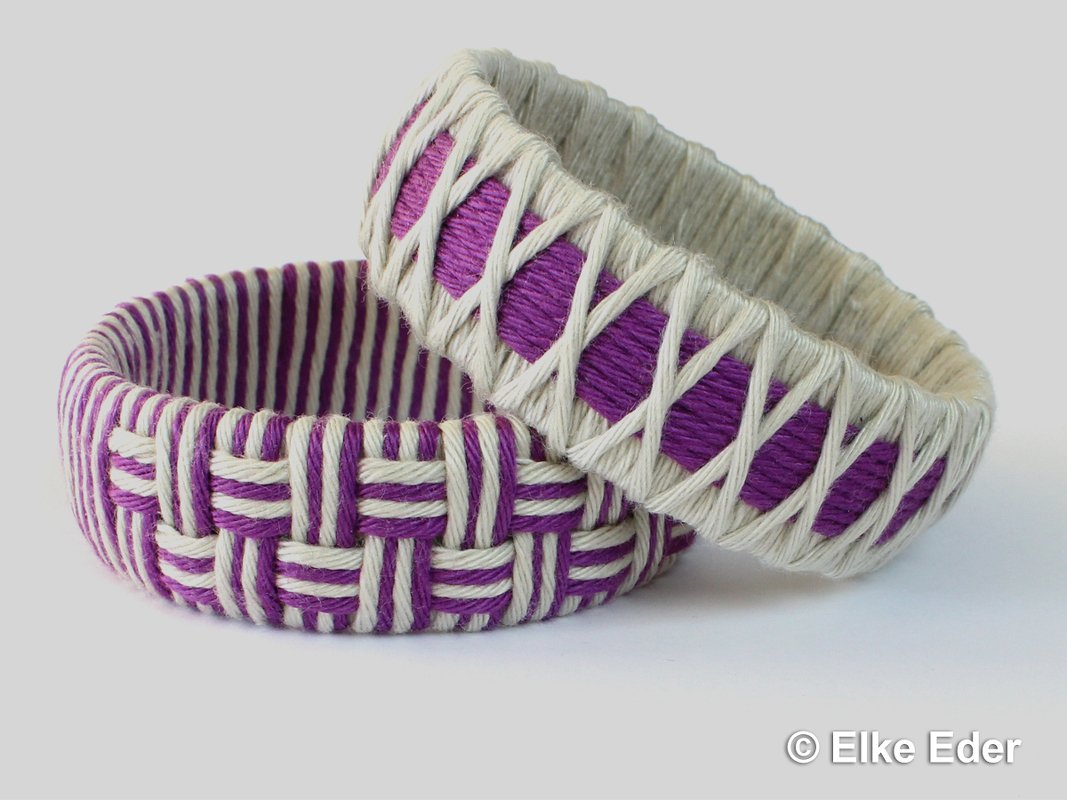 Close-up of two rigid bangles wrapped in purple and cream twine demonstrating basket-weave and cross-wrap patterns