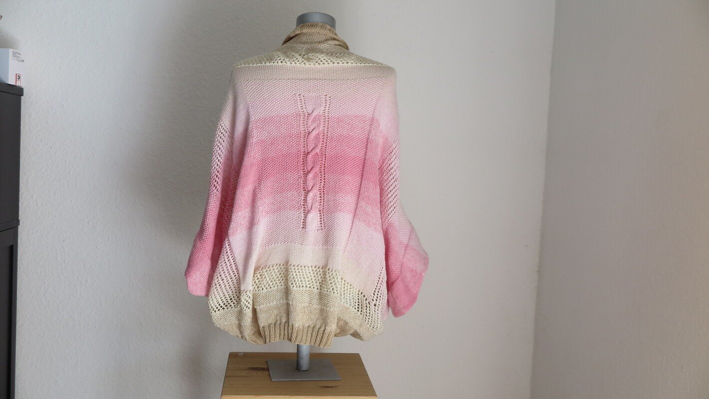 Rückansicht eines gestrickten Seelenwärmers in Rosa und Beige mit mittigem Zopf und Lochsaum auf Büste