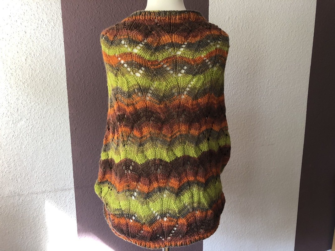 Rückansicht gestrickter Seelenwärmer in Grün, Orange und Braun mit welligem Lochmuster