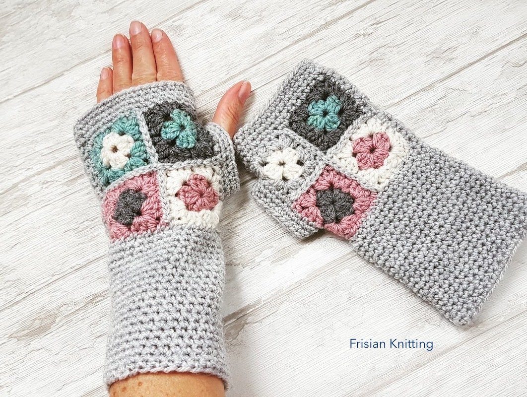 Hellgraue gehäkelte Armstulpen mit pastellfarbenen Granny-Squares, eine getragen, eine daneben