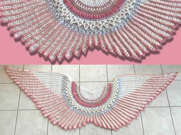 Winged fan-shaped crochet shawl in pink, white, and light blue laid flat, showing radiating stitches and scalloped edge.