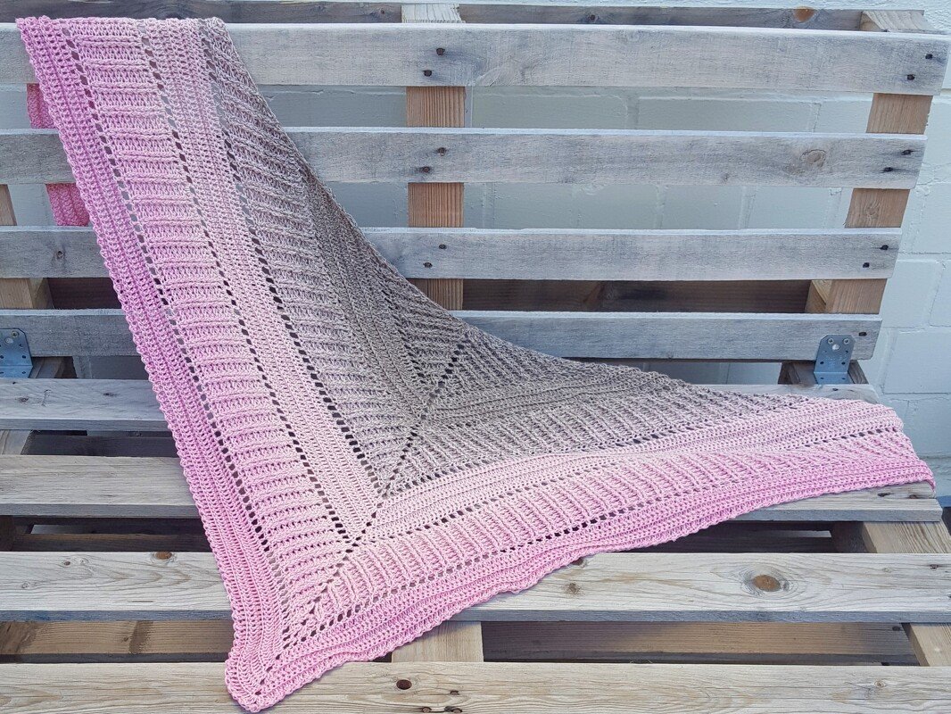 Gehäkeltes Dreieckstuch mit Farbverlauf in Rosa und Braun auf Holzpaletten