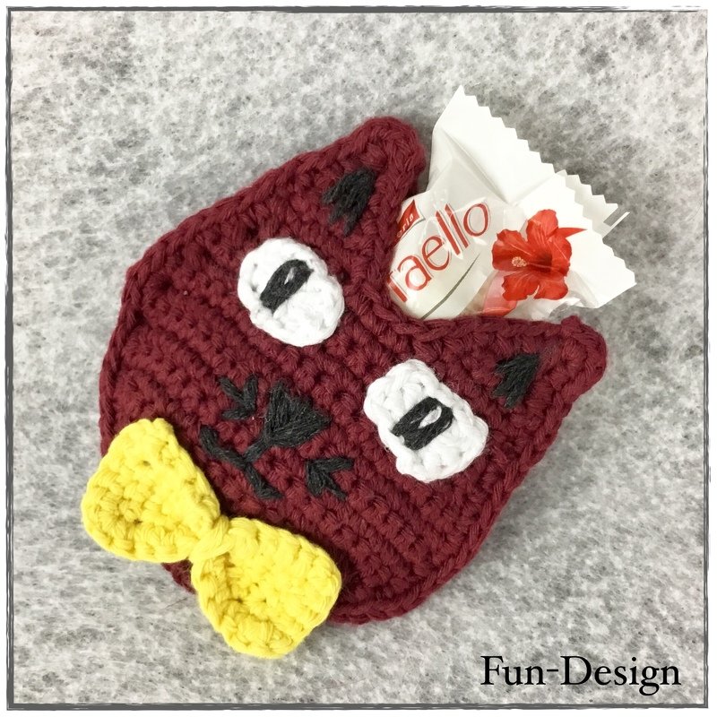 Dunkelrote gehäkelte Eule mit weißen Augen und gelber Schleife