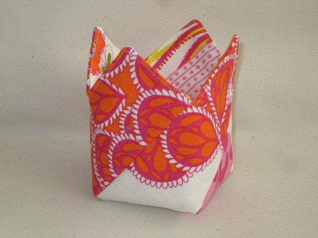 Quadratisches Stoffutensilo mit orange-rosa Muster und gefalteten, gezackten Ecken