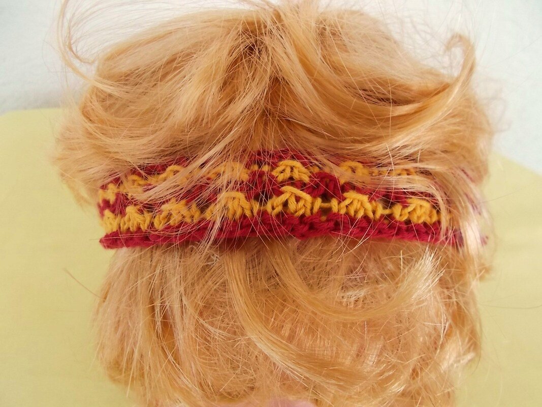 Rückansicht eines roten und gelben gestrickten Stirnbands an blondem Haar