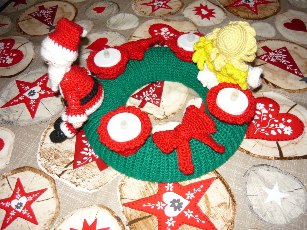 Gehäkelter grüner Adventskranz mit vier roten Teelichthaltern, roter Schleife und gehäkelten Figuren