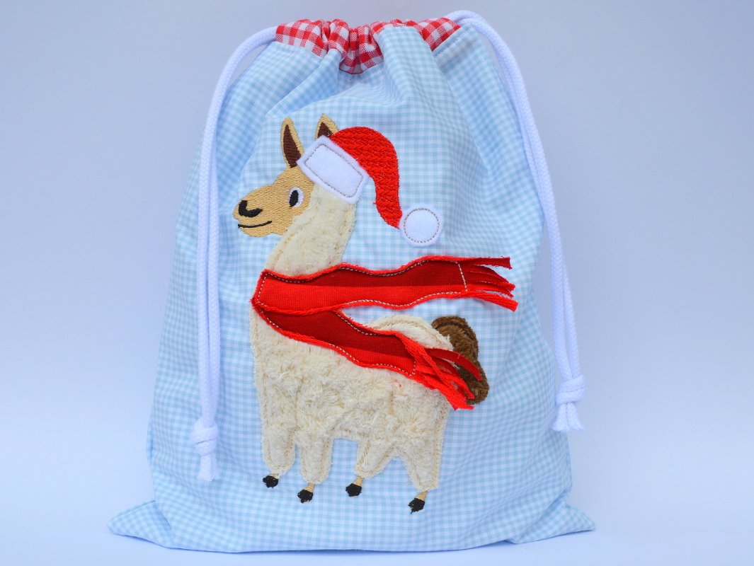 Stickdatei für Kordelzug-Beutel: Alpaka mit rotem Schal und Nikolausmütze auf kariertem Stoff