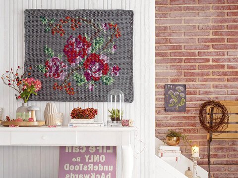 Gehäkelter Wandbehang mit Kreuzstichrosen