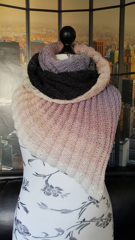 Asymmetrical ribbed crochet triangle shawl in pale beige, mauve and charcoal draped on a mannequin