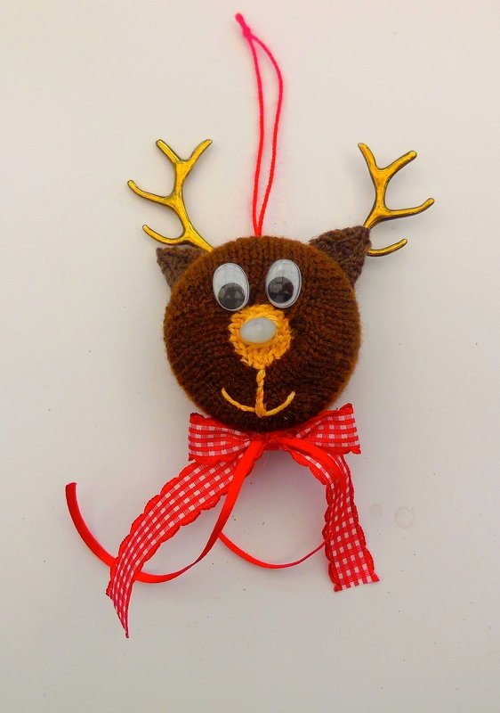 Gestrickter brauner Rentierkopf mit Wackelaugen, goldfarbenen Geweihen und rot-weiß kariertem Band