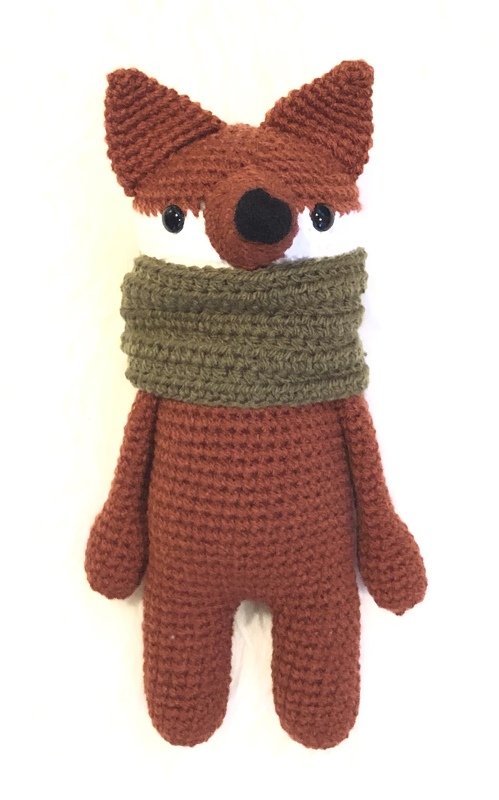 Gehäkelter Amigurumi-Fuchs in Rostbraun mit olivgrünem Schal