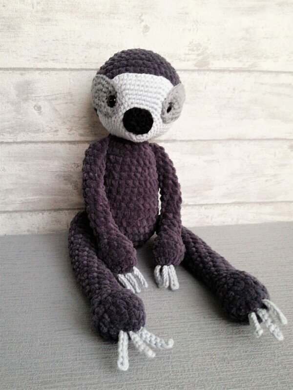 Gehäkeltes Faultier-Amigurumi in Dunkellila und Hellgrau, sitzend