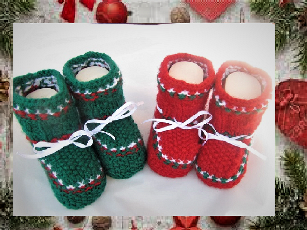 Zwei Paare gestrickter Babyschuhe in Grün und Rot mit weißen Bändern