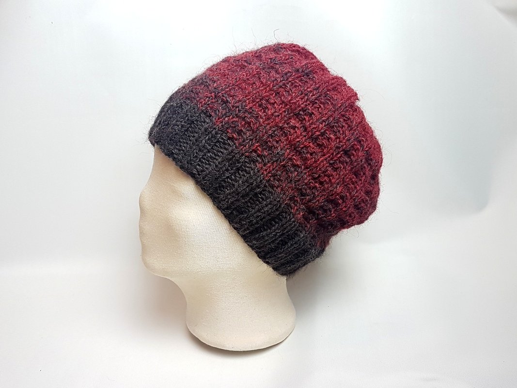 Gestrickte Beanie in Dunkelgrau und Bordeaux auf Schaufensterkopf