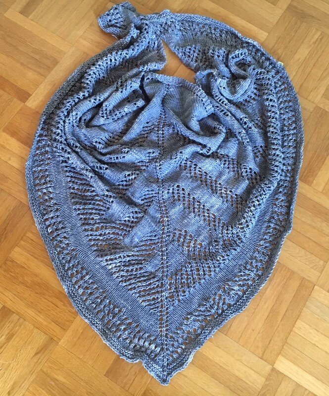 Gestricktes dreieckiges Lacetuch in Blaugrau mit Lochmuster, auf Parkett ausgelegt