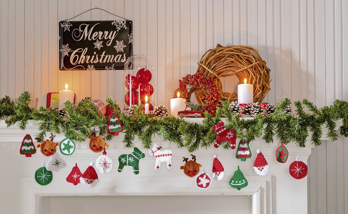 DIY-Girlande aus gehäkelten Weihnachtsanhängern in Rot, Grün und Weiß über einem Kamin