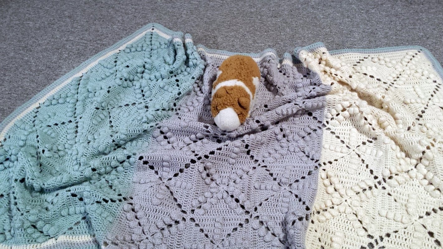 Gehäkelte Babydecke in Mint, Grau und Creme mit Noppenquadraten und kleinem Plüschtier