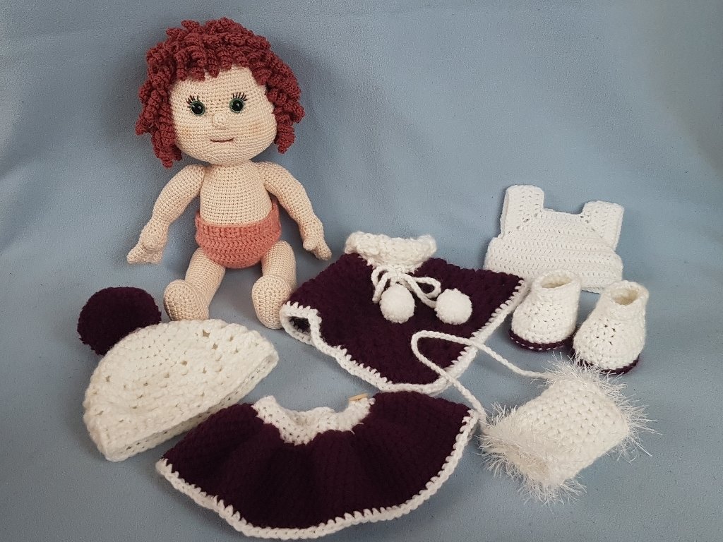 Gehäkelte Amigurumi-Puppe mit wechselbarer Kleidung: Mütze, Rock, Cape, Body, Schühchen und Tasche