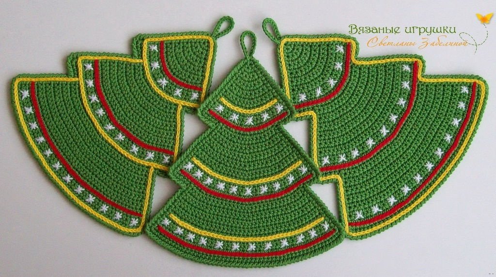 Grüne gehäkelte Topflappen in Tannenbaum- und Halbkreisform mit gelben und roten Borten sowie weißen Sternstichen