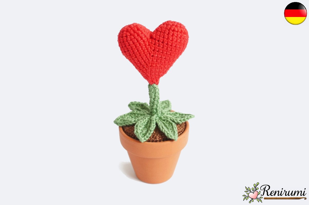 Gehäkeltes Herz auf Stängel mit Blättern in kleinem Topf