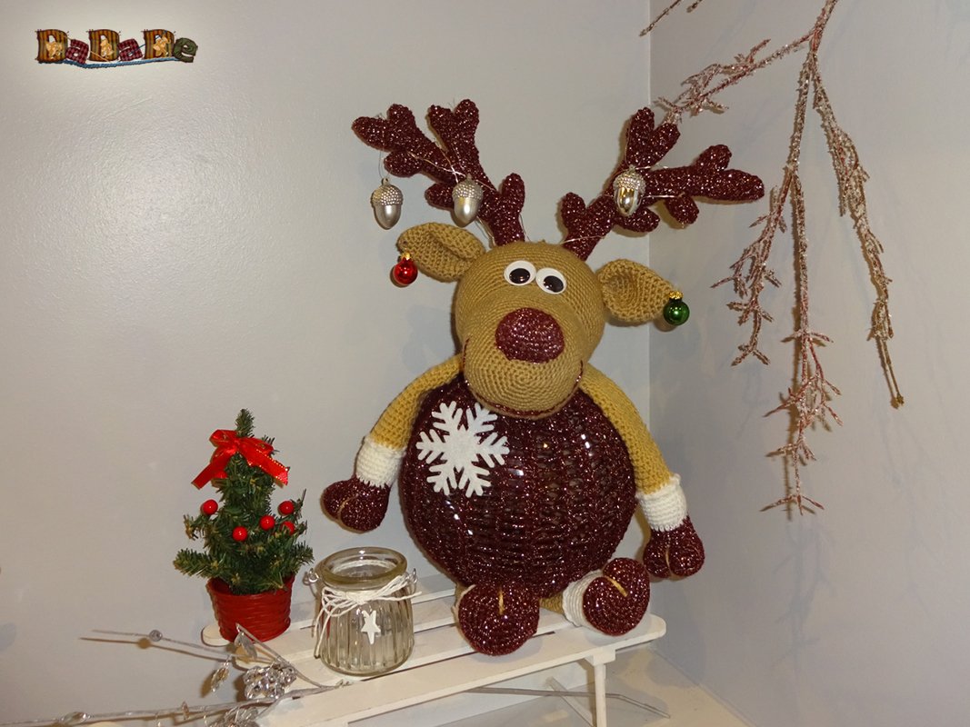 Gehäkeltes Rentier mit glitzerndem Körper, daneben Mini-Weihnachtsbaum und Teelichtglas