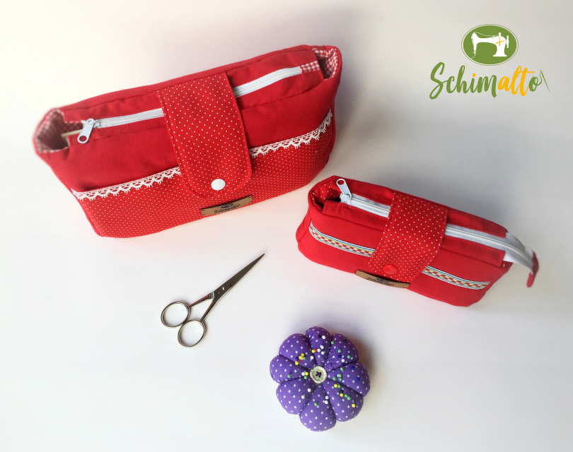 Zwei rote Utensilo-Taschen, Nähschere und violettes Nadelkissen