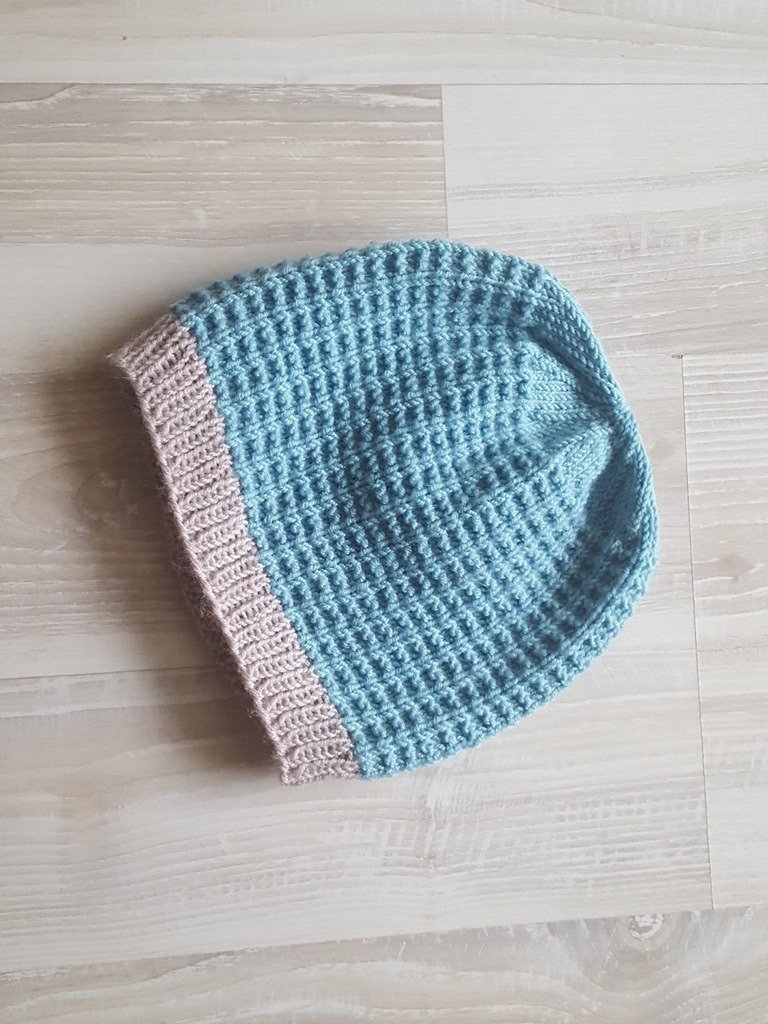 Gestrickte Babymütze hellblau mit beigem Rippbündchen, flach ausgelegt