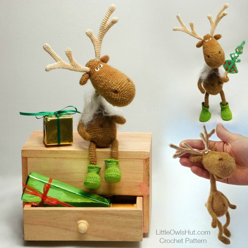 Brown crocheted amigurumi reindeer with beige antlers and green boots sitting on a wooden box next to small wrapped gifts