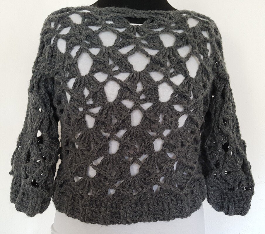 Grau gehäkelter Damenpullover mit Ajour-Lochmuster auf Schaufensterpuppe